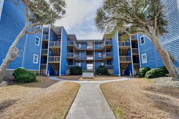 Blue apartment complex with outdoor stairs and walkways.