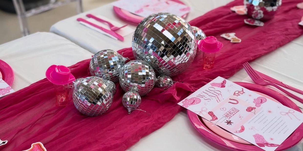 Shiny disco balls and pink-themed table setting for a festive event.