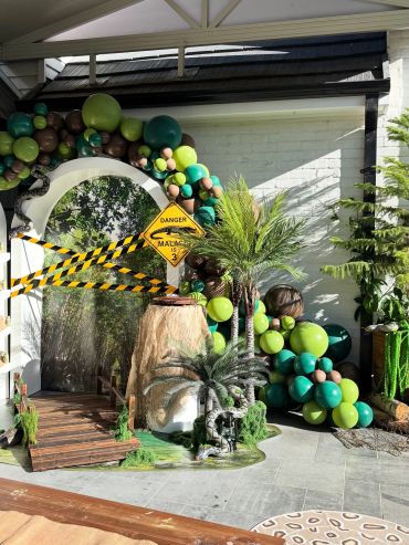 Jungle-themed party setup with balloons and caution signs.