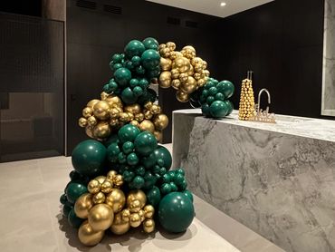 Green and gold balloon arrangement decorating a modern kitchen.