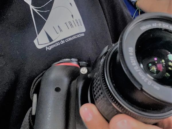 Persona con cámara y camisa de La Tribu Agencia de Comunicaciones