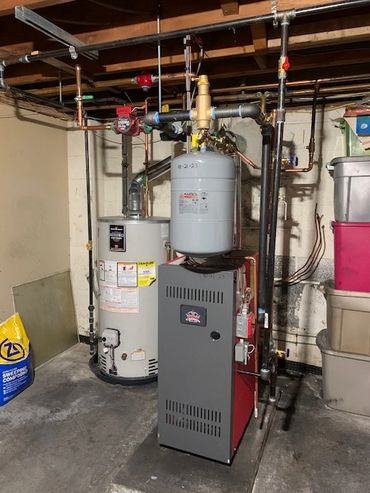 Basement utility area with water heater and boiler system.