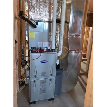 New Carrier HVAC unit installed in a wooden-framed basement.