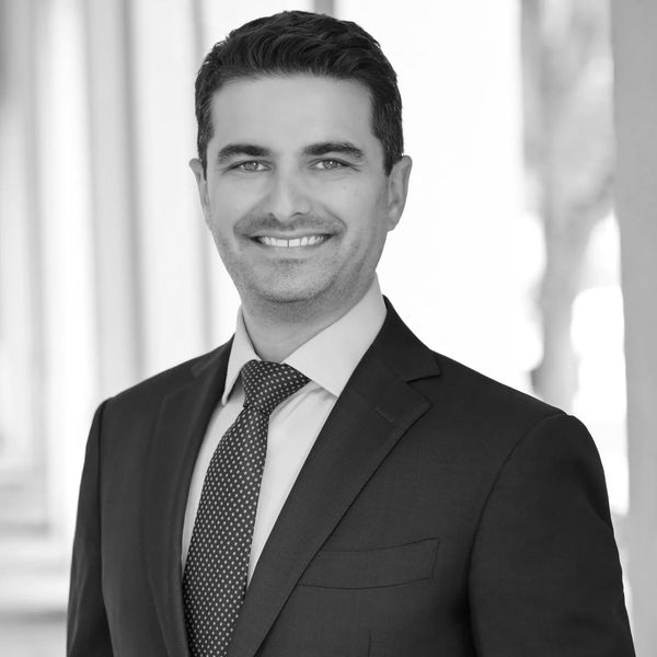 Professional man in a suit smiling confidently.