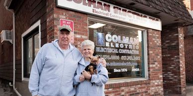 Photo of Colman Electric street front with man and woman and small dog