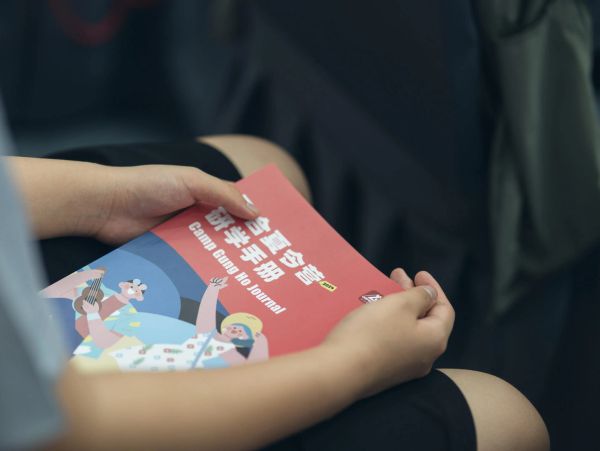 Person holding a colorful camp journal with illustrations.
