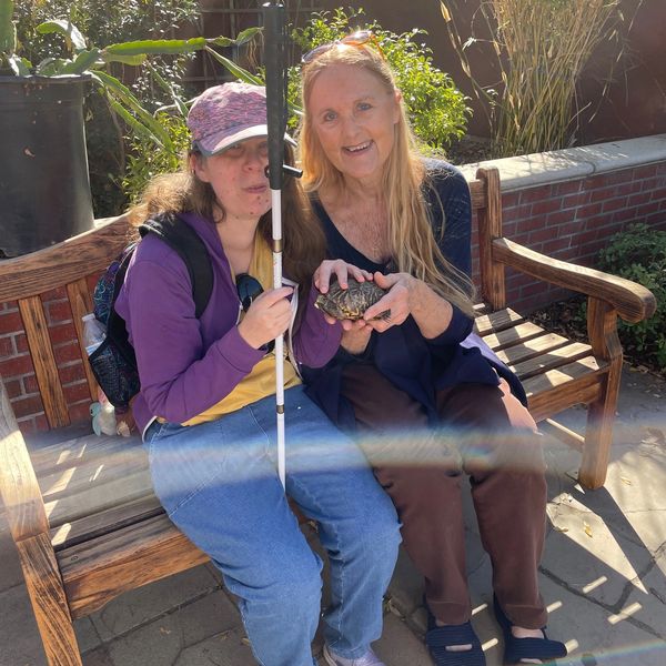 the elderly women are sitting on chairs and looking ahead.