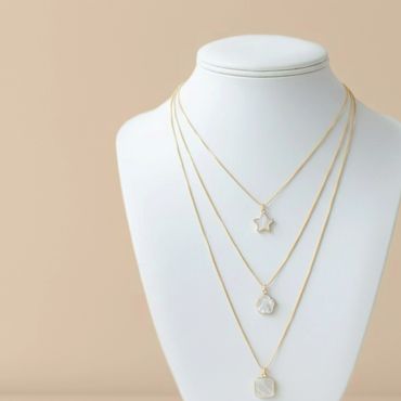 Elegant layered gold necklaces with star and geometric pendants.