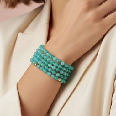 Elegant turquoise beaded bracelet worn on wrist with cream blazer.