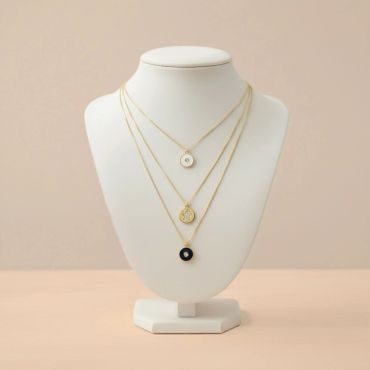 Three elegant gold necklaces with distinct pendants displayed on a white bust.