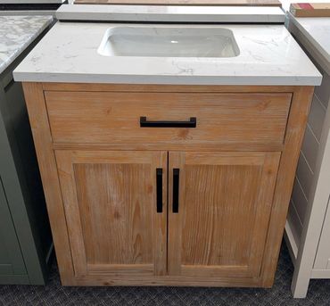 Wooden bathroom vanity with white countertop.