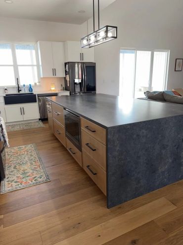 Modern kitchen with large island and wooden accents.