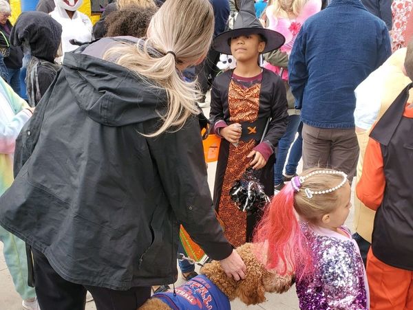 Photo of Lt. Det. Michelle Day and K9 Remy talking to children at Halloween Trunk or Treat event