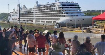 Gran crucero transitando por las esclusas del Canal de Panamá mientras los visitantes observan su pa