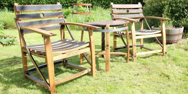 A pair of whisky barrel stave carver style chairs with a matching barrel top table 