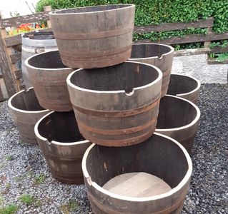 A stack 1/2 hogshead whisky barrel planter tubs ready for the garden by wee dram barrel creations