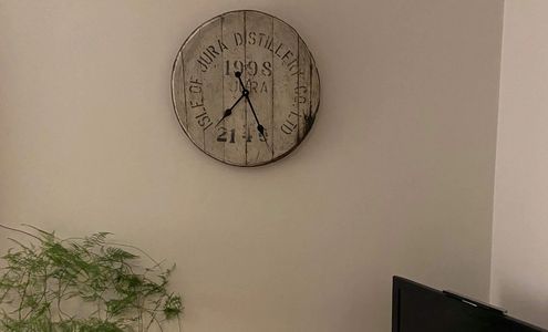 hogshead whisky barrel top clock from the isle of jura distilliery hanging on a living room wall 