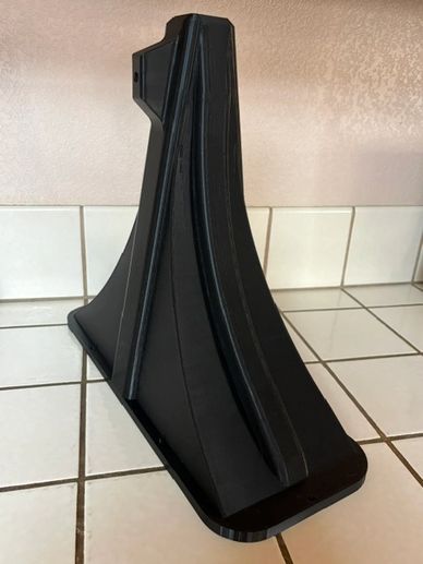 Black plastic stand or mount on a tiled surface.