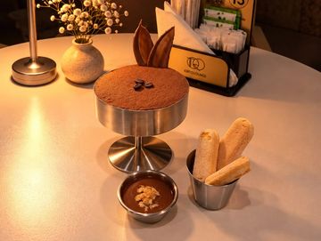 Elegant dessert setup with tiramisu and biscuits.