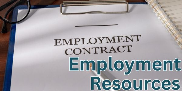 Close-up of an employment contract on a clipboard with a notebook and glasses nearby.