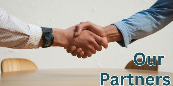 Two people shaking hands over a table symbolizing partnership.