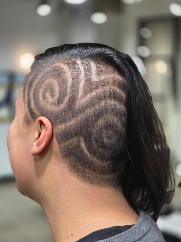 Intricate shaved swirl design hairstyle on one side.