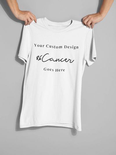 White T-shirt held up with customizable cancer awareness design.