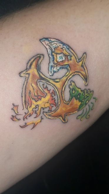 Colorful tattoo combining elements of fire, water, and nature on skin.