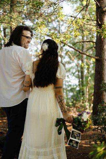 Couple in forest with flowers and ultrasound photos.