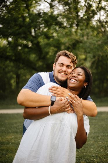 A joyful couple embracing outdoors in a green park.
