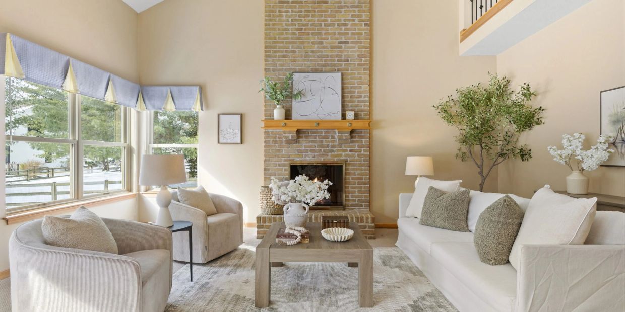 Cozy living room with neutral tones and a brick fireplace.