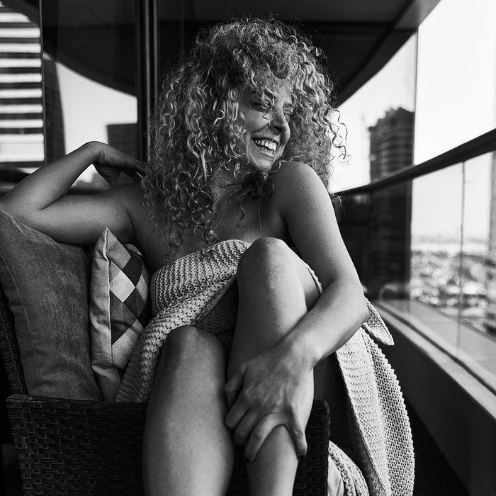 Female model with curly hair on a balcony