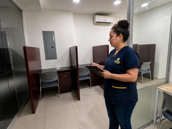 Supervisora operativa verificando estándares de limpieza y mantenimiento en oficinas corporativas