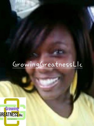 A smiling woman with dark hair wearing a yellow top, with GrowingGreatnessLlc watermark.