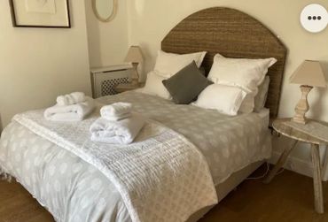Cozy bedroom with a neatly made bed and folded towels.