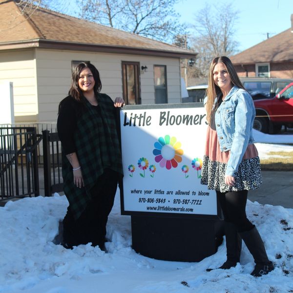 Our directors in front of our sign and Johnstown location
