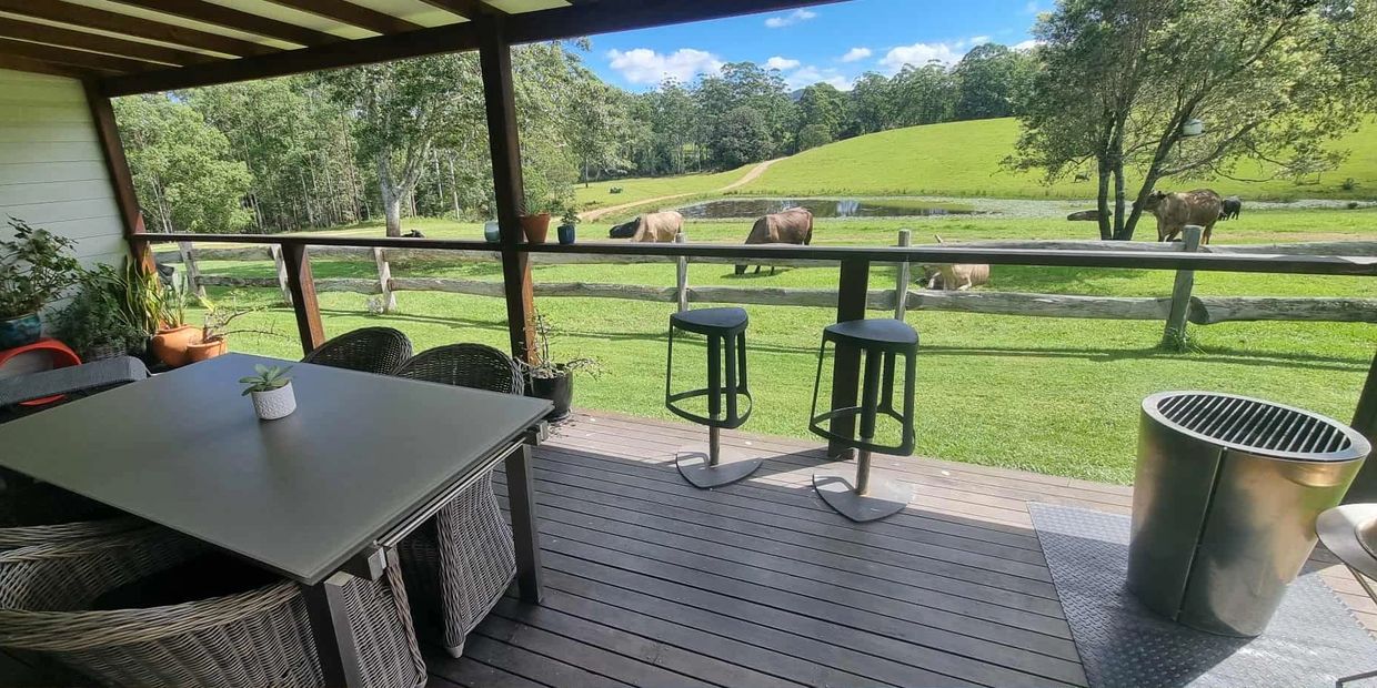 Deck view over dam and rolling hills with Brahman cattle at The Gallery Farm, Collombatti.