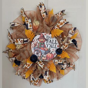 Fall-themed wreath with a scarecrow and pumpkins.
