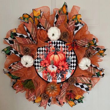 Fall-themed welcome wreath with pumpkins and pinecones.
