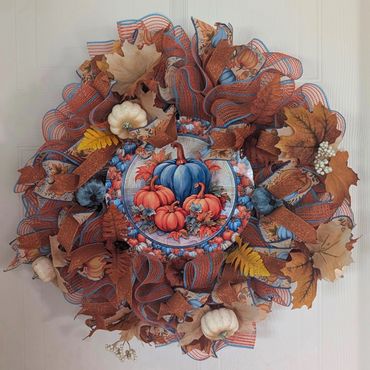 Autumn-themed decorative wreath with pumpkins and leaves.