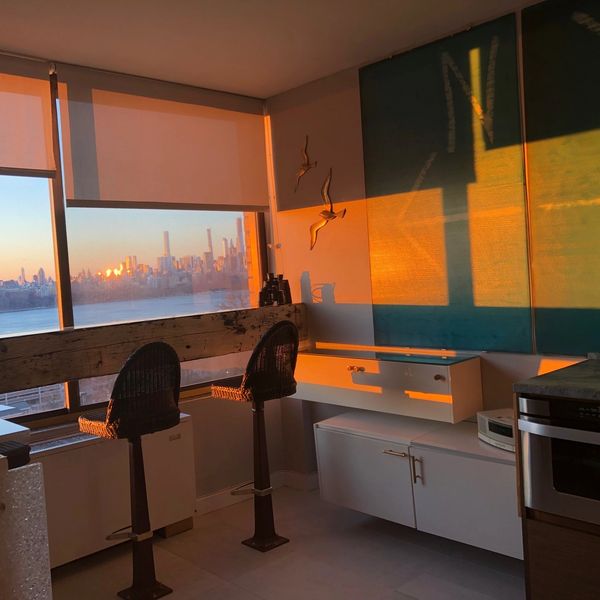 NYC sunrise views with floating rough hewn bar,  NYC  glass backsplash, quartzite floor, mcm decor.