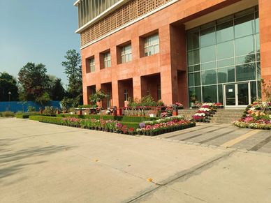 A modern building with a landscaped garden and flowers in front.