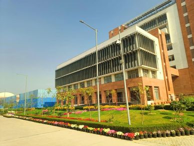 Modern building with landscaped gardens and clear blue sky.