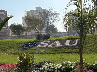 A landscaped garden with 'SAU' spelled out in flowers and greenery.