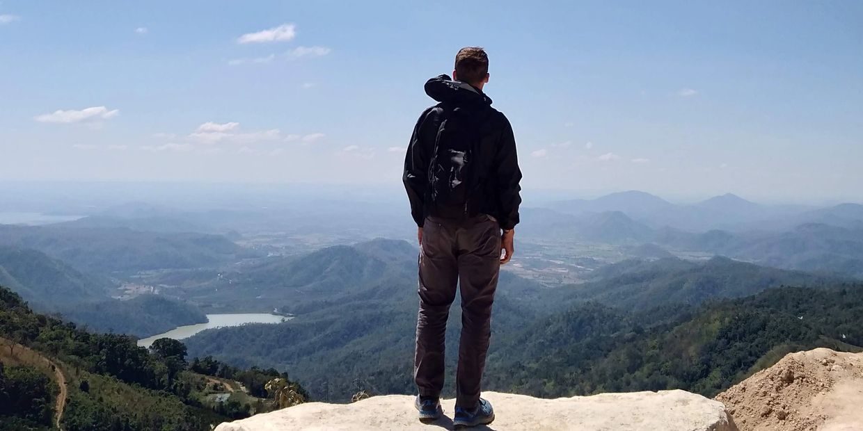 Man looking at scenic mountain view from a viewpoint. 