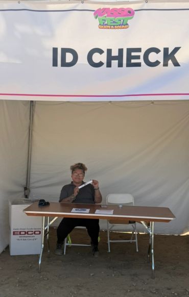 Person at an ID check desk under a tent.