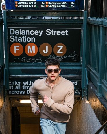Man running up subway stairs at Delancey Street Station.