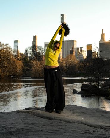 Person stretching outdoors in city park during sunset.