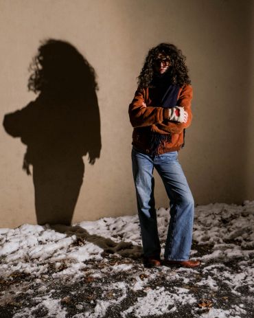 Person in winter clothes casting a shadow on the wall.