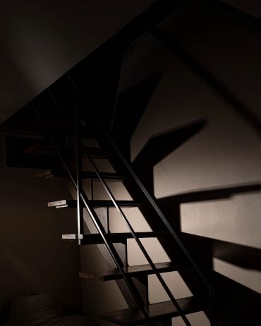 Shadowed staircase with dramatic lighting.